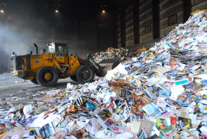 Recycling rates are increasing, but so is ‘contamination’ - A construction vehicle next to a truck - Recycling