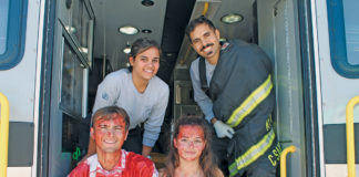 Two-day party features swimsuit fashion show and axe throwing - A group of people standing around a bus - Car