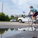 Cyclists go 125 miles to support children’s shelter - A man riding a bicycle next to a lake - Road bicycle