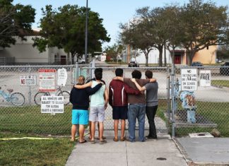 How local schools are facing the surge of national violence - A group of people standing on a sidewalk - Gun violence