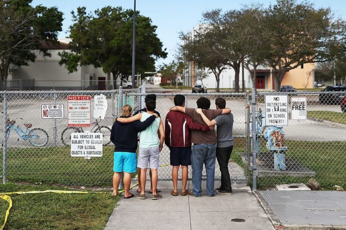 How local schools are facing the surge of national violence - A group of people standing on a sidewalk - Gun violence