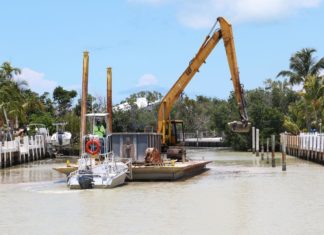 Canal dredging: 2 down, 8 to go - A boat is docked next to a body of water - Canal