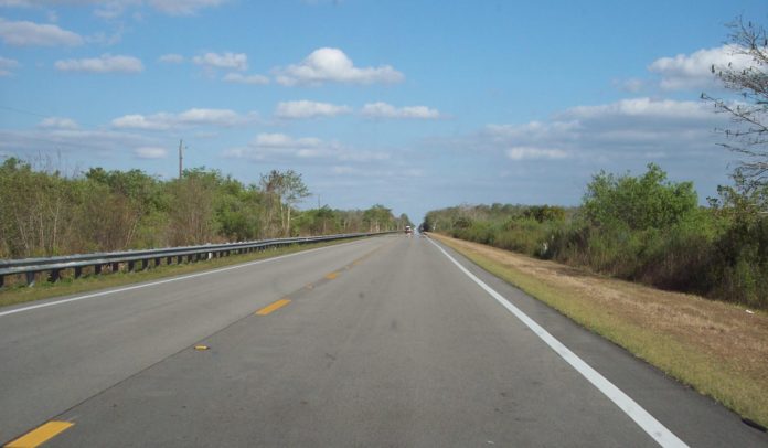 Governor DeSantis Announces Full Funding Now in Place for Critical Tamiami Trail Project - An empty road with trees on the side of a highway - Tamiami Trail