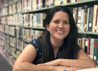 THE NEW LIBRARIAN Lorena Diaz takes the reins of Marathon’s public library - A woman sitting at a table in front of a book shelf - Lorena Diaz