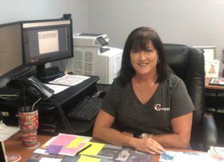 Committed to Excellence – Principal Acevedo looks ahead to the Fall - A woman sitting at a table in front of a computer - Florida Keys