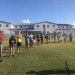 Putting the Band Back Together – KWHS Marching Band prepares for the field - A group of people standing on top of a grass covered field - Team