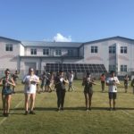 Putting the Band Back Together – KWHS Marching Band prepares for the field - A group of people playing frisbee in front of a building - Musical ensemble