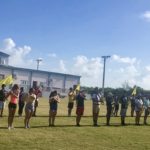 Putting the Band Back Together – KWHS Marching Band prepares for the field - A group of people standing on top of a grass covered field - KEY WEST HIGH SCHOOL