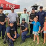 COMMUNITY PARTNERS – Family, food and fun with first responders - A group of people standing in front of a crowd posing for the camera - iT'Z