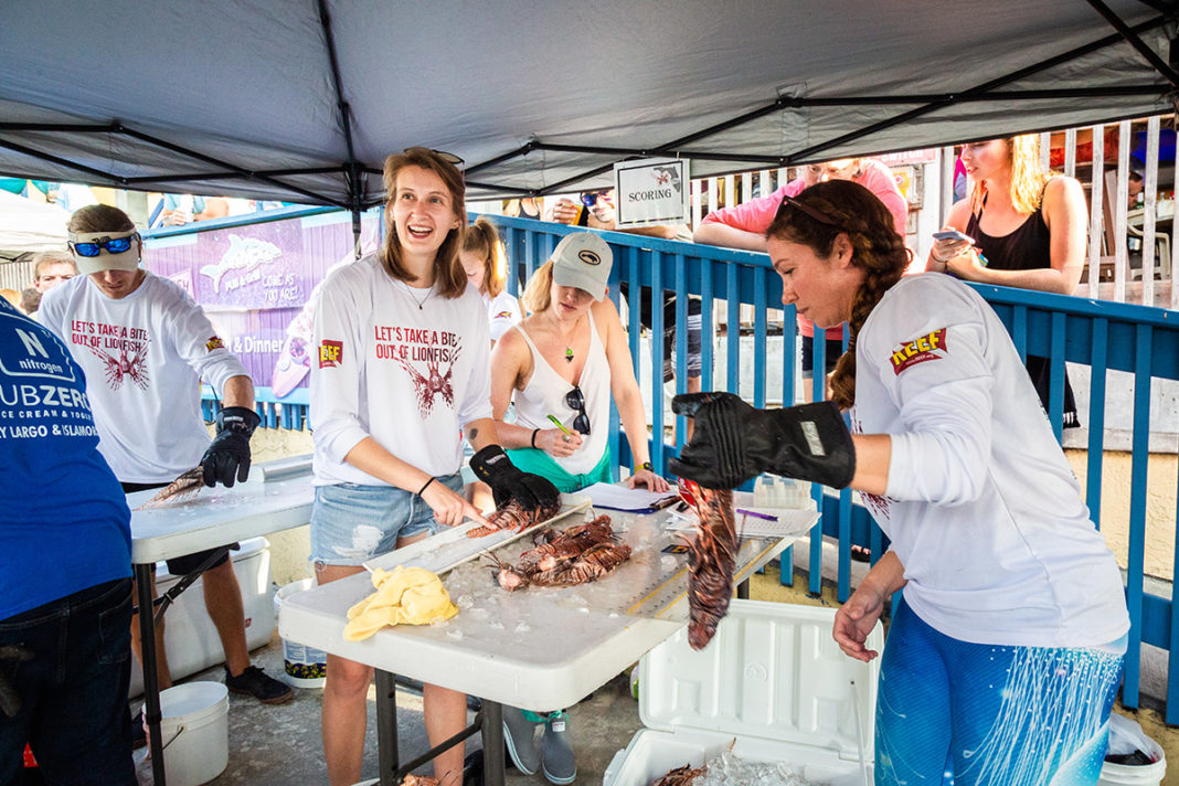 Lionfish Derby at Postcard Inn set for Sept. 13-15 - A group of people standing around a table - Weekly Newspapers