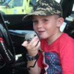 TOP COPS – National Night Out draws a crowd - A little boy wearing a helmet sitting in a car - Car