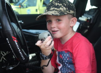 TOP COPS – National Night Out draws a crowd - A little boy wearing a helmet sitting in a car - Car