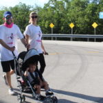 A man and woman pushing a baby stroller