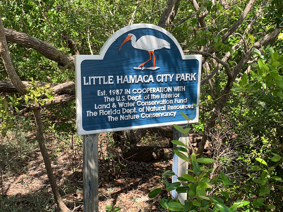 Little Hamaca Park offers a hidden hideaway - A blue sign sitting in the grass - Nature reserve