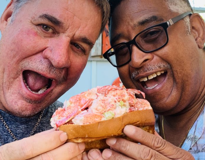 Rolling for a Cause – Local Lobster Roll-Eating Contest benefits Bahamas. - A man eating a sandwich - Eating