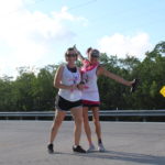 PINK ARMY – Inaugural bra walk in Key Largo sees large support - A woman walking down a road - Car