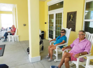 Rocking chairs line the front porch at Poinciana Gardens, where residents Barbara Jones, Joseph Canosa and others enjoy the shaded breeze and easy conversation.