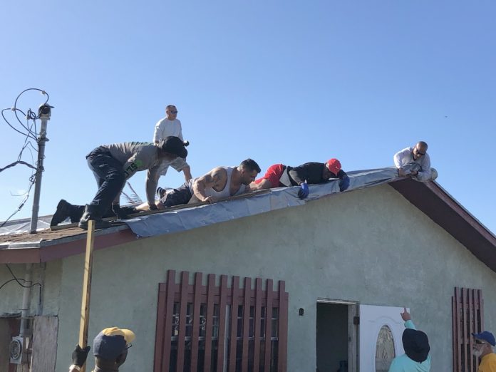 A group of people standing on the side of a building - Facade