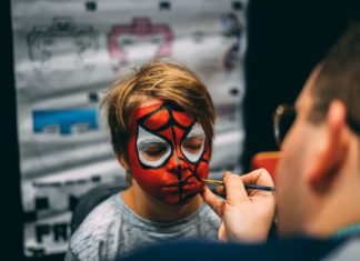 GROWN-UP PARTY GIVES WAY TO YOUNGER CROWD – KIDS COUNT DOWN TO TRICK-OR-TREATING - A close up of a person talking on a cell phone - Painting