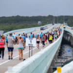 A group of people running on a bridge - Marathon