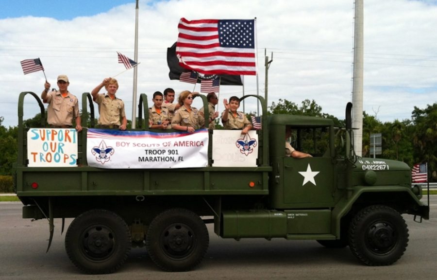  - A group of people riding on the back of a truck - Military Displays