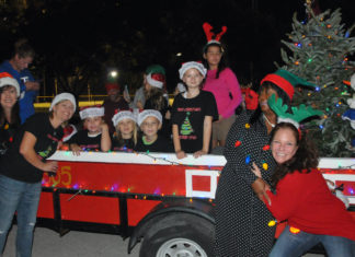 ‘CARING AND SHARING AROUND THE WORLD’ – Hammon grand marshal of Islamorada Holiday Parade - A group of people riding on the back of a truck - Fête