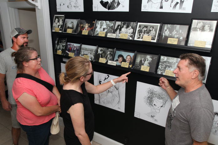 Tennessee Williams Museum opens new exhibit – Rare photos show playwright’s personality - A group of people standing in a room - Art exhibition