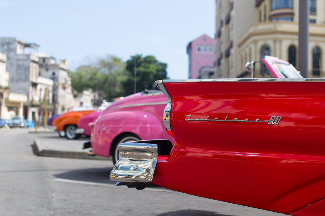 Learn about how to travel to Cuba at Marathon Library talk - A red car parked on the side of a road - Vintage car