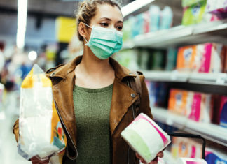 a woman wearing a face mask while shopping in a grocery store