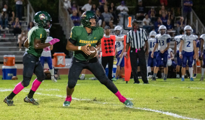 a football player holding a football on a field