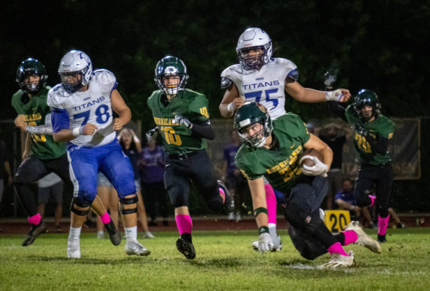 a football game with a player running for the ball