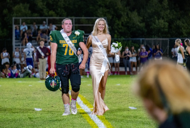 a couple of people that are walking on a field