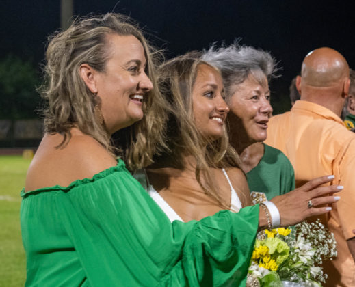 a group of women standing next to each other on a field