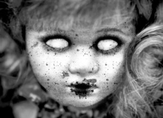 a black and white photo of a creepy doll