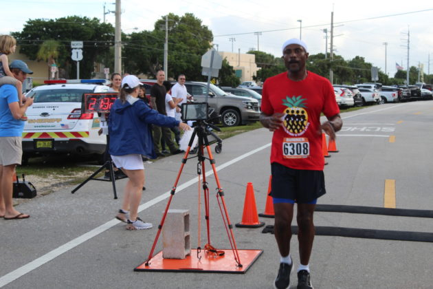 a man in a red shirt is running in a race