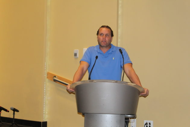 a man standing at a podium in front of a microphone