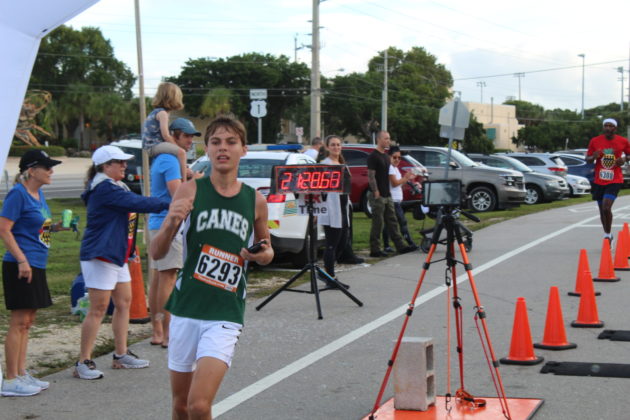 a man running in a race through orange cones