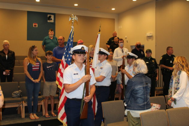 a group of people standing in a room with flags