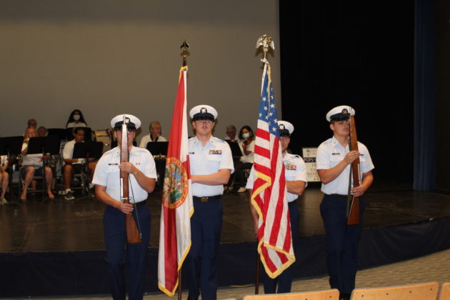 a group of men standing next to each other holding flags