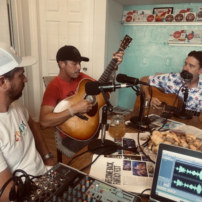 a group of men sitting around a table with guitars