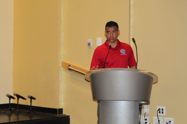 a man standing at a podium in front of a microphone