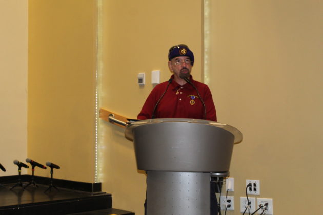 a man standing at a podium in front of microphones