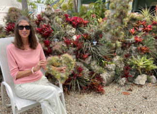 a woman sitting in a chair in front of some plants