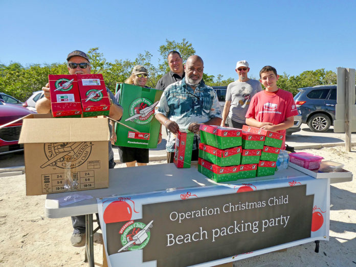 OCC-1 a group of people standing around a table with boxes on it
