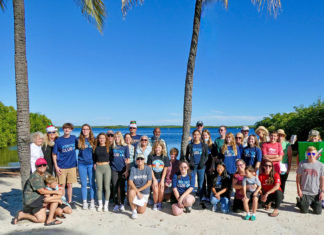 a group of people posing for a picture on the beach