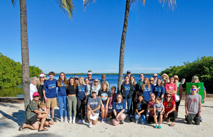 a group of people posing for a picture on the beach