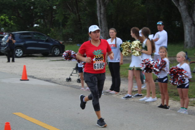 a man running down a street with cheerleaders behind him