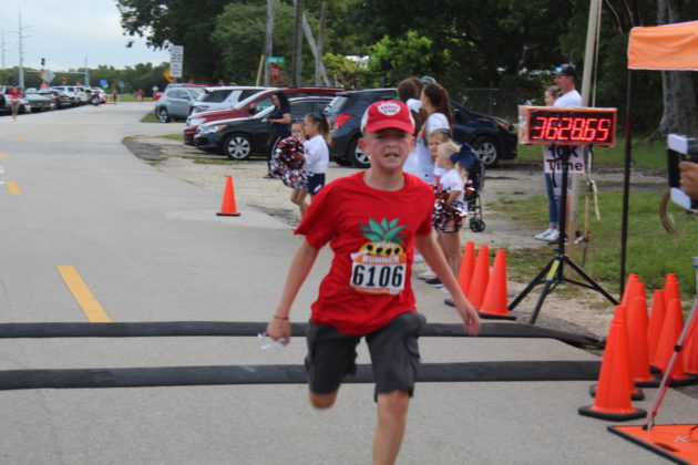 a young boy is running in a race
