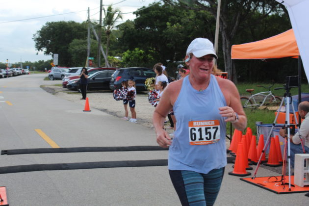 a woman running in a race with orange cones around her