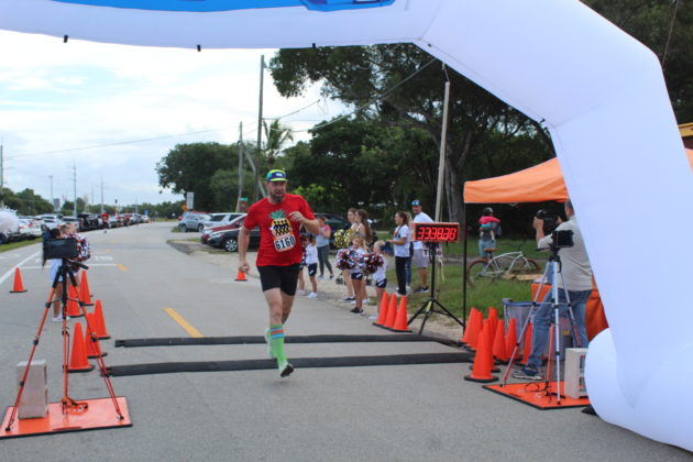 a man in a red shirt is running in a race